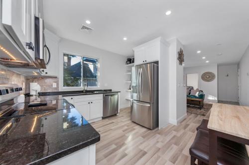 a kitchen with white cabinets and a stainless steel refrigerator at Private Luxury Framingham condo near Boston in Framingham