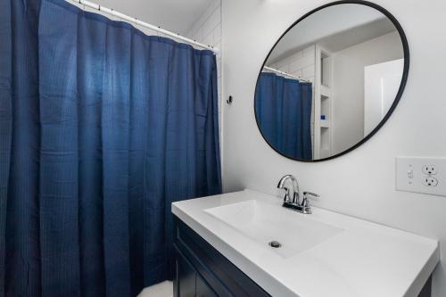 a bathroom with a blue shower curtain and a sink at Private Luxury Framingham condo near Boston in Framingham