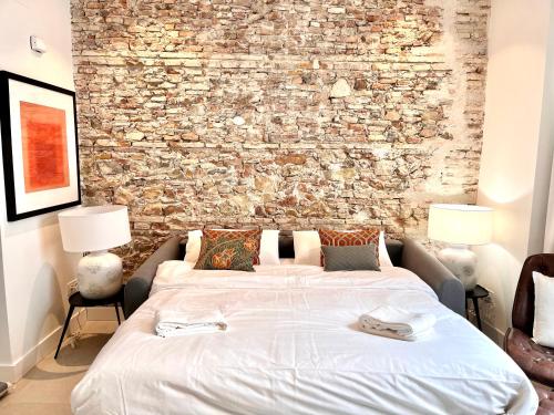 um quarto com uma cama grande e uma parede de pedra em Homely Málaga Mariblanca 17, Vegafuente Apartments em Málaga