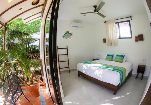 a bedroom with a bed and a large window at Maison Bacalar in Bacalar