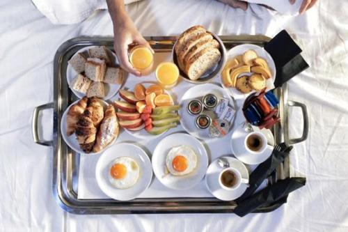 bandeja de alimentos para el desayuno en una cama en Hotel Lotus, en Salvador