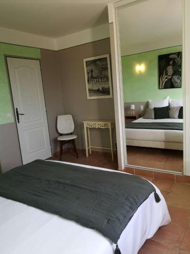 a bedroom with a large bed and a mirror at Chez TATA in Régusse