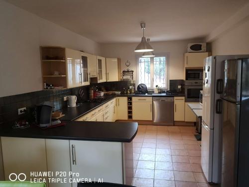 a kitchen with white cabinets and a black counter top at Chez TATA in Régusse