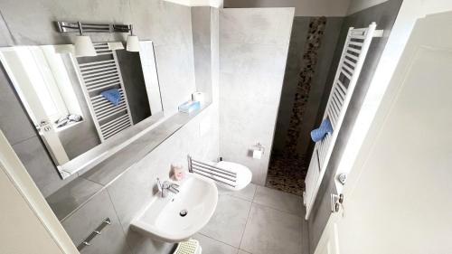 a white bathroom with a sink and a mirror at "Bauernhof-Claussen", Haus Seestern in Sahrensdorf