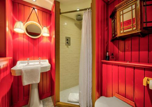 a red bathroom with a sink and a shower at Rock House - Photographer's Studio - Historic Gem in the heart of the City in Edinburgh