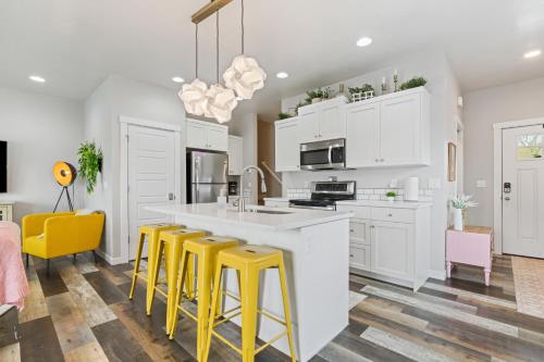 a kitchen with white cabinets and yellow bar stools at Deco Townhouse - 3 bedroom 2 story private home in Caldwell