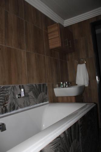 a bathroom with a bath tub and a sink at The Villa 442 in Pretoria