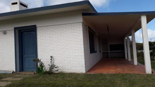 una casa de ladrillo blanco con puerta azul en Casa a media cuadra de la playa, en La Paloma