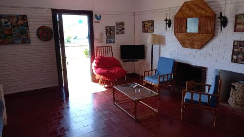 sala de estar con 2 sillas y chimenea en Casa a media cuadra de la playa, en La Paloma