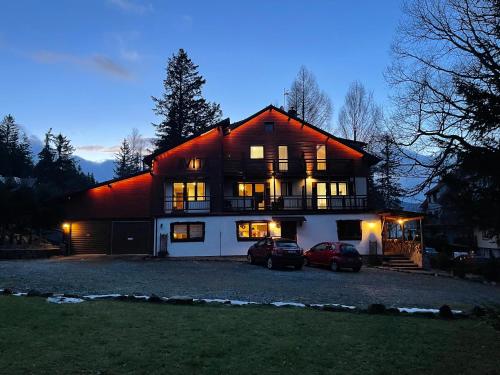 a large house with two cars parked in front of it at Willa Avita in Karpacz