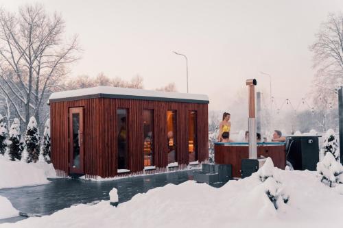 a small building in the snow with people standing in it at Dolina Barw - całoroczne domki na wynajem in Rabka