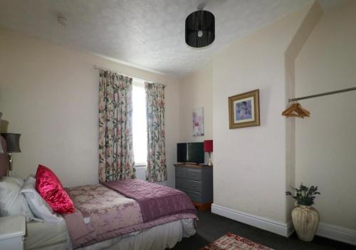 a bedroom with a bed and a tv and a window at Regent Apartment 1 in Blackpool