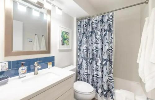 a bathroom with a toilet and a shower curtain at Ilikai Marina Vacations in Honolulu