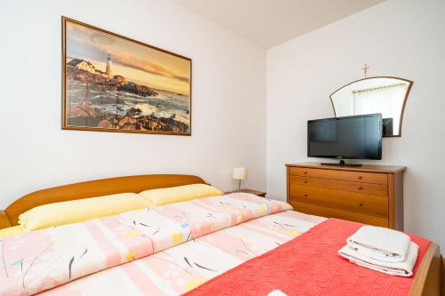 a bedroom with a bed and a tv on a dresser at SPACIOUS THREE BEDROOM APARTMENT in Dubrovnik