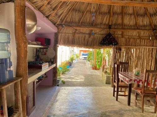 a kitchen and dining room with a table in a hut at Posada Xtakay Bacalar ''Turix'' in Bacalar