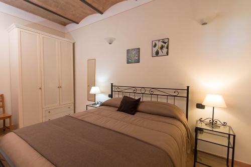 a bedroom with a bed and two lamps on tables at Agriturismo Podere Camollia in Costalpino
