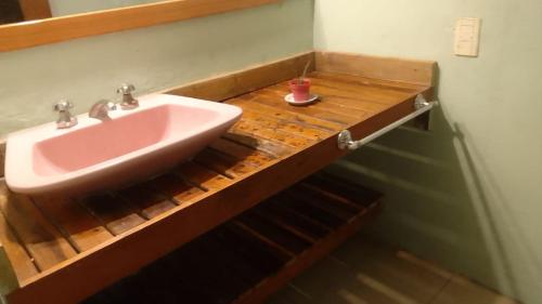 baño con lavabo rosa en una encimera de madera en es lo que hay en Ostende