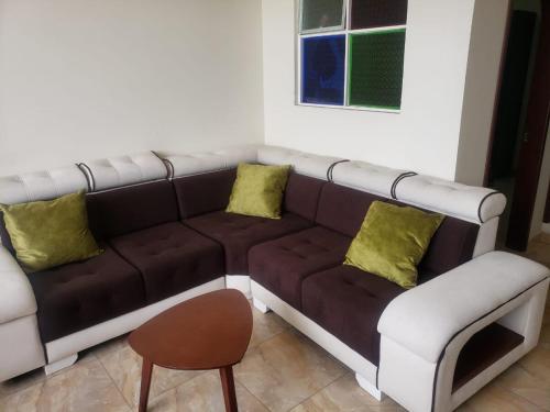 sala de estar con sofá marrón y silla en Apartaestudio de lujo, en Pasto