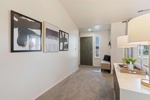 a living room with white walls and a hallway with a door at Modern Comfort Caldwell 3b2b Home Sleeps 8! in Caldwell