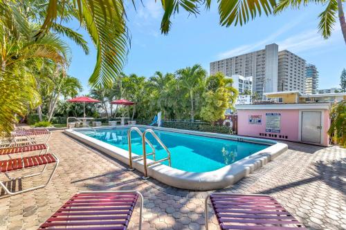 uma piscina com cadeiras e um resort em Seahorse Guesthouse em Pompano Beach