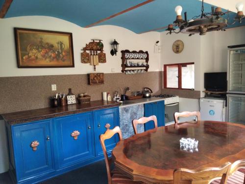 a kitchen with blue cabinets and a wooden table at Atlantis Apartmán 3 in Klášterec nad Ohří