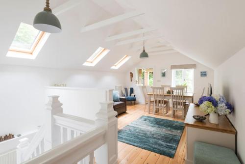 a living room and dining room with white ceilings at The Coach House at Lower Coombe Royal- Family/Dogs in Kingsbridge