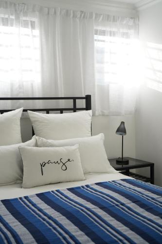 1 dormitorio con 1 cama con manta azul y blanca en Nature's Rest, en Ciudad del Cabo