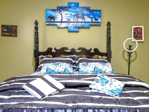 1 dormitorio con 1 cama con almohadas azules y blancas en Lima's Vacation 1BR Apt with Wi-Fi & Netflix in Kampala, Namugongo road, en Kampala