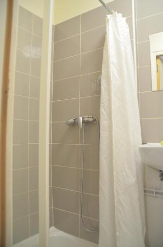 une salle de bain avec un rideau de douche et un lavabo dans l'établissement Super Appartement à deux pas du jardin des plantes, à Rouen