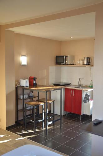 une petite cuisine avec une table et un micro-ondes dans l'établissement Super Appartement à deux pas du jardin des plantes, à Rouen