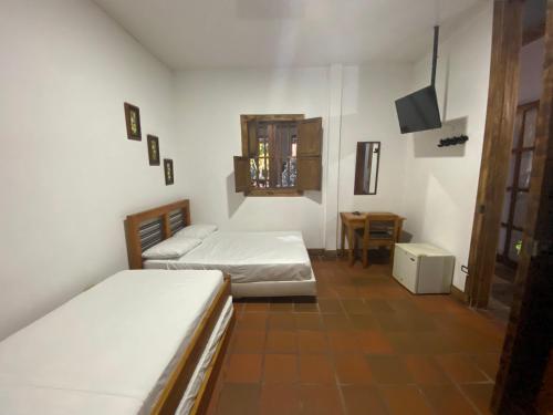 Habitación pequeña con 2 camas y TV. en Hotel Trujillo Plaza en Trujillo
