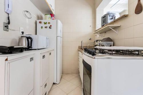 a kitchen with white appliances and a white refrigerator at Apartamento encantador no Guarujá, praia da Enseada - Apenas 600m da praia ! in Guarujá