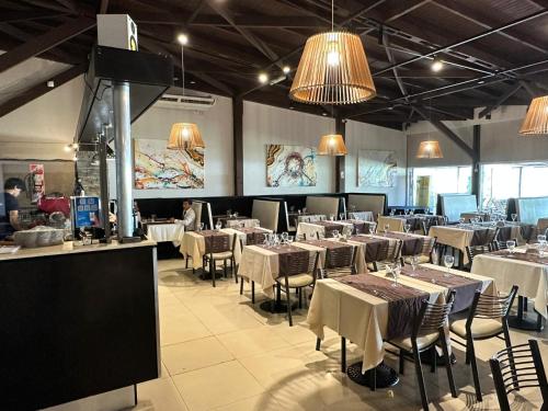 un comedor con mesas, sillas y luces en Howard Johnson Marinas & Resort en San Pedro
