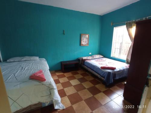 a bedroom with green walls and a bed and a window at CASA BELINDA in Santiago Atitlán