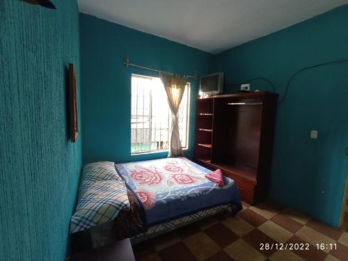 a bedroom with a bed and a window at CASA BELINDA in Santiago Atitlán