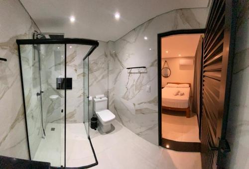 un letto e un bagno con doccia e servizi igienici. di Villa Licuri Boiçucanga a Boicucanga