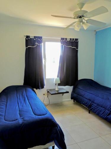 um quarto com 2 camas e uma ventoinha de tecto em Chalet Kuyen III em Las Grutas