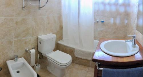 uma casa de banho com um WC, um lavatório e uma banheira em Chalet Kuyen III em Las Grutas