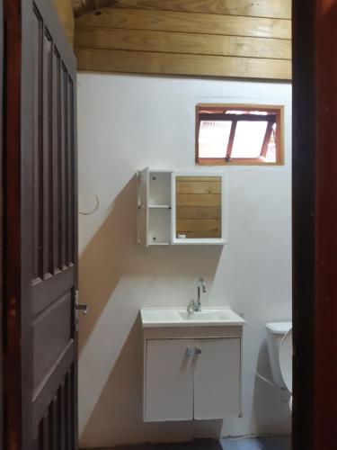 a bathroom with a sink and a toilet at Casa Rústica praia da Ferrugem próximo praia com piscina compartilhada in Garopaba