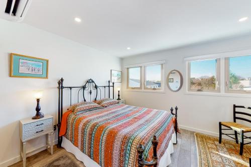 a bedroom with a bed and two windows at Mariners Court - 4 Laurel St Unit 219 in Rehoboth Beach