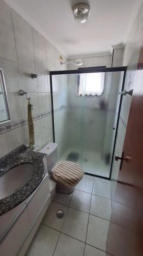 ein Bad mit einer Dusche, einem WC und einem Waschbecken in der Unterkunft 074 Cantinho da Praia - 1 quarto c/ varanda - 200 m da praia - WI FI e com área de lazer - PISCINA e Salão de Jogos e ESTACIONAMENTO GRATUITO in Praia Grande