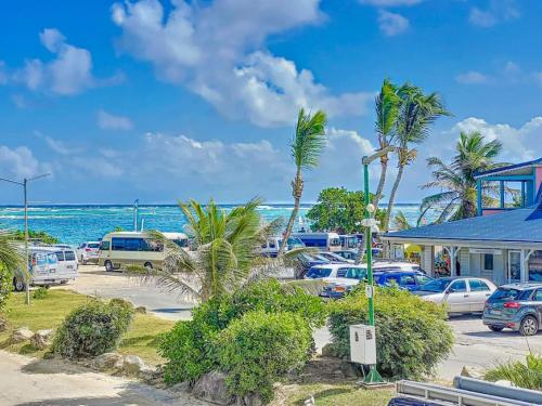 a parking lot next to the ocean with palm trees at The Beach central 50m from Orient Bay Beach in Orient Bay