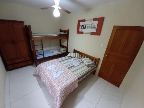 - une petite chambre avec un lit et une porte en bois dans l'établissement Chácara Helenna Colonetti, à Lindóia