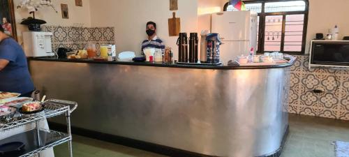 um balcão de metal numa cozinha com pessoas atrás dele em Pousada Romeiros do Pai Eterno - Santuario Basilica de Trindade em Trindade