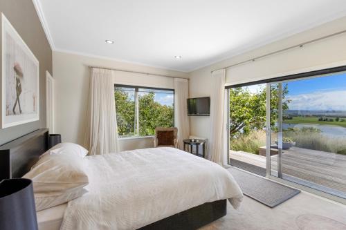 1 dormitorio con cama grande y ventana grande en Slice of Heaven - Napier Holiday Home en Napier