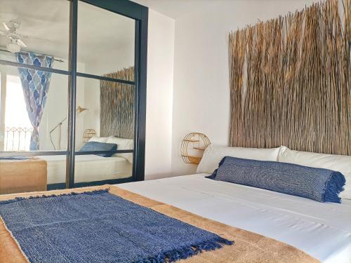 a bedroom with a white bed and a large window at Casa Bakara Zahara beach in Zahara de los Atunes