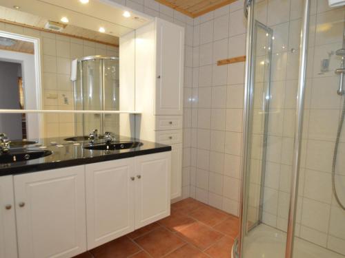 a bathroom with two sinks and a glass shower at Villa Chapter Two in Niedernsill
