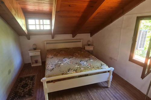 a bedroom with a bed in a room with two windows at Casaquinta en la costa del Rio in General Roca