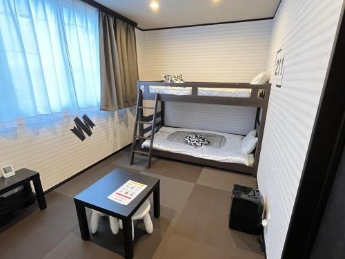 a small room with two bunk beds and a table at SAMURISE 81INN - Vacation STAY 60979v in Azagawa