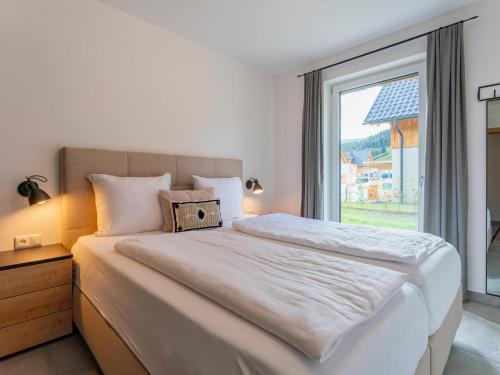 a bedroom with a large bed with a large window at Mountain Chalet An der Mur in Sankt Lorenzen ob Murau